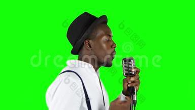 美国黑人男音乐家一半的营业额在录音棚唱歌。 绿色屏幕。 关门